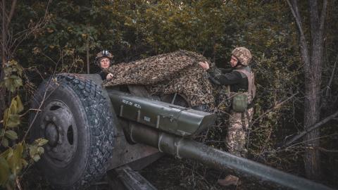 Soldiers pulling down camouflage netting from a 122 mm howitzer 2A18 before combat work as Ukrainian forces with the 117th territorial defense brigade operate an artillery position on June 19, 2025 in the Sumy region of Ukraine. (Nikoletta Stoyanova via Getty Images)