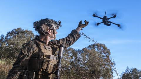 An intelligence specialist activates a Skydio X2 small unmanned aerial system to survey the defensive line for opposing forces during a simulated assault and seizure at Glen Airfield in Queensland, Australia, in July 2025. (US Marine Corps)