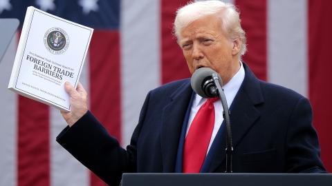  U.S. President Donald Trump holds up a copy of a 2025 National Trade Estimate Report as he speaks during a “Make America Wealthy Again” trade announcement event in the Rose Garden at the White House on April 2, 2025 in Washington, DC. Touting the event as “Liberation Day”, Trump is expected to announce additional tariffs targeting goods imported to the U.S. (Photo by Chip Somodevilla/Getty Images)
