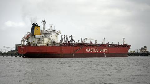 The cargo ship Castle Ships is seen near industrial structures along the shoreline under overcast skies in Mumbai, India, on April 1, 2026. (Photo by Indranil Aditya/NurPhoto via Getty Images)