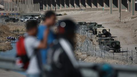 CIUDAD JUAREZ, MEXICO - JANUARY 08: Texas National Guard soldiers stand guard as migrants continue to wait at the U.S.-Mexico border on January 08, 2023 in Ciudad Juarez, Mexico. President Joe Biden made his first visit since taking office to the US-Mexico border on Sunday, spending four hours in El Paso in the US state of Texas. El Paso is currently the biggest corridor for illegal crossings in the US. (Photo by Christian Torres/Anadolu Agency via Getty Images)