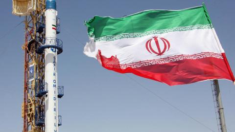 An Iranian flag fluttering in front of Iran's Safir Omid rocket at an undisclosed location on August 16, 2008. (Vahidreza Alai/AFP via Getty Images)