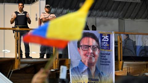 Policemen stand guard while supporters of slain Ecuadorian presidential candidate Fernando Villavicencio pay their respects during an act organized by the Movimiento Construye party and friends at the Quito Exhibition Center in Quito on August 11, 2023. (Rodrigo Buendia/AFP via Getty Images)