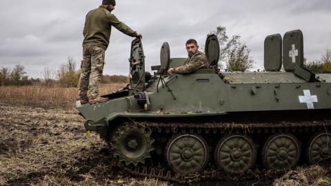 Two Ukrainian army mechanics repair a broken MT-LB in Kharkiv, Ukraine, on October 25, 2024. (Fermin Torrano/Anadolu via Getty Images)