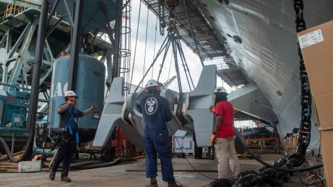 Newport News Shipbuilding contractors lift the starboard anchor of the Nimitz-class aircraft carrier USS John C. Stennis in Newport News, Virginia, on July 14, 2023. (US Navy photo)