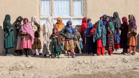 Afghan women and children stand outside a primary healthcare center in Ghazni, Afghanistan, on February 2, 2025. (Mohammad Faisal Naweed/AFP via Getty Images)