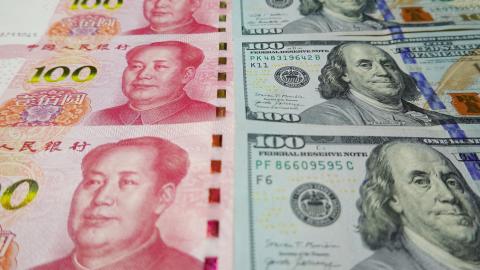 100 US dollar notes and 100 Yuan notes are displayed. (Sheldon Cooper/SOPA Images/LightRocket via Getty Images)