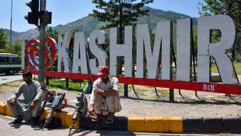 Workers wait along a road in Muzaffarabad, the capital of Pakistan-administered Kashmir, on May 14, 2025. (Sajjad Qayyum via Getty Images)