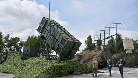 Ukrainian servicemen walk past a Patriot air defense system at an undisclosed area on August 4, 2024. (Sergei Supinsky via Getty Images)