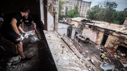 Workers collect glass and debris after a Russian Shahed drone strikes the city of Kharkiv, Ukraine, on July 30, 2025. (Francisco Richart Barbeira via Getty Images)
