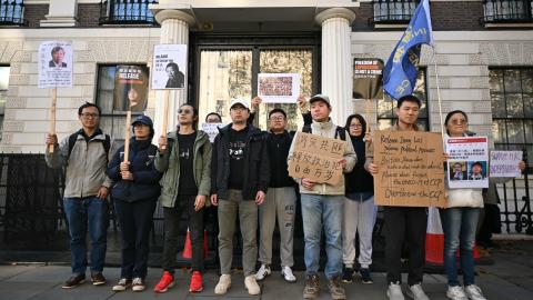 Protesters hold placards as they gather for a demonstration outside the Chinese Embassy in London on November 8, 2025. (Getty Images) Share to Twitter