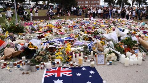 Mourners gather around floral tributes at Bondi Pavilion to honor the victims of the Bondi Beach shooting in Sydney, Australia, on December 16, 2025. (Getty Images)