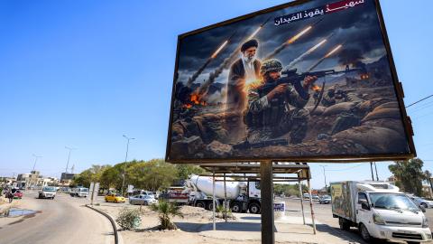 A billboard depicting Iran’s late supreme leader standing behind an Iranian soldier with a caption in Arabic reading "a martyr leads the battlefield" in western Baghdad on March 18, 2026. (Getty Images)