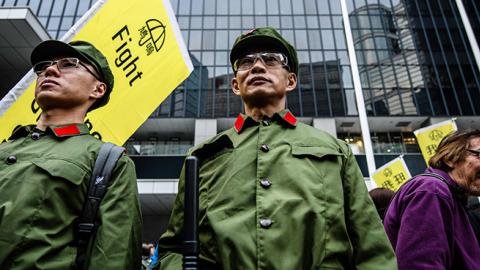 Protesters dress up as members of the Chinese Liberation Army (PLA) at the recently reopened Civic Square as they take part in the annual New Year's Day pro-democracy rally in Hong Kong on January 1, 2018.