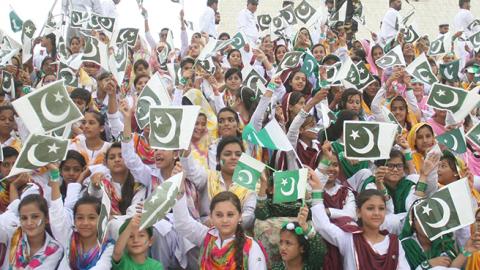 Pakistani girls hold Pakistani flags during a ceremony marking Pakistan's 69th Independence Day, August 14, 2016