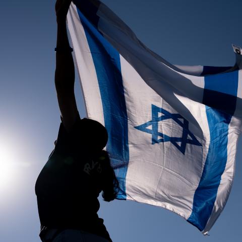 The Washington Monument is visible as a woman holds an Israeli flag at the October 7th Memorial Rally in Washington, DC, on October 7, 2024. (Getty Images) Share to Twitter